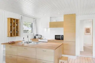 a kitchen with white walls and a wooden counter top at BL1668-Blokhus-Skraavejen-4 in Blokhus