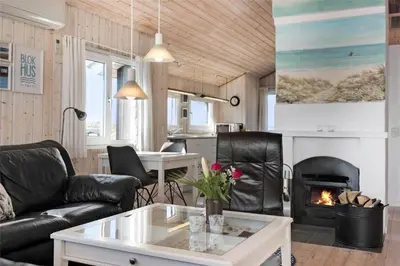 a living room with leather furniture and a fireplace at BL971-Blokhus-Slugten-10 in Blokhus