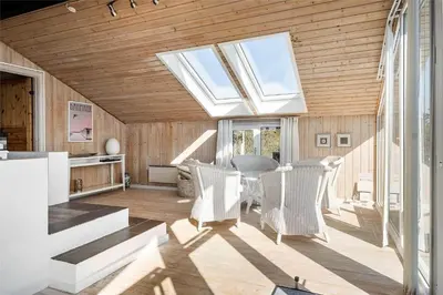 a living room with a skylight and a table and chairs at BL971-Blokhus-Slugten-10 in Blokhus