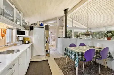 a kitchen with a table and purple chairs in it at BL164-Saltum-Lyngsletten-7 in Saltum