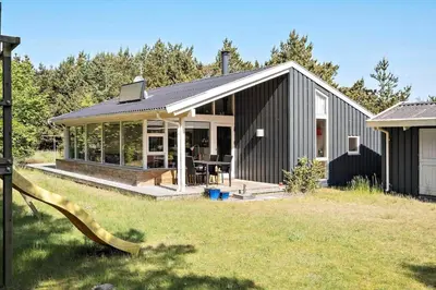 a black house with a slide in the yard at BL164-Saltum-Lyngsletten-7 in Saltum
