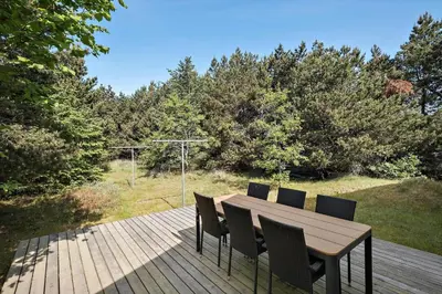 a wooden table and chairs on a wooden deck at BL164-Saltum-Lyngsletten-7 in Saltum