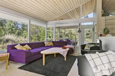 a living room with a purple couch and a table at BL164-Saltum-Lyngsletten-7 in Saltum