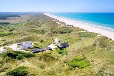 a house on a hill next to the beach at BL1483-Blokhus-Ved-Skoven-25 in Blokhus