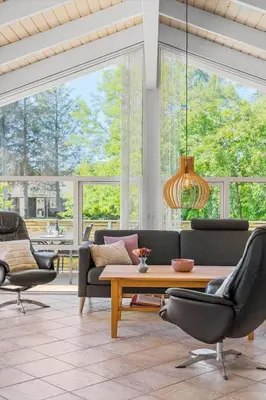 a living room with a couch and a table and chairs at BL1761-Blokhus-Hojmarksvej-44 in Blokhus