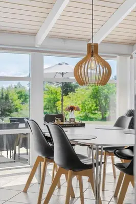 a dining room with a table and chairs and a chandelier at BL1761-Blokhus-Hojmarksvej-44 in Blokhus