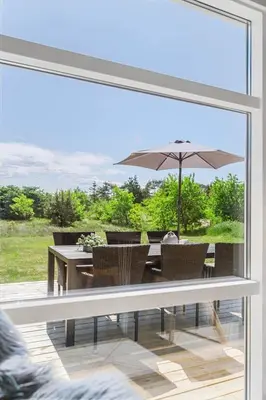 a patio with a table and an umbrella at BL1761-Blokhus-Hojmarksvej-44 in Blokhus