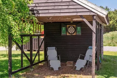 a gazebo with two chairs and a clock at BL1761-Blokhus-Hojmarksvej-44 in Blokhus