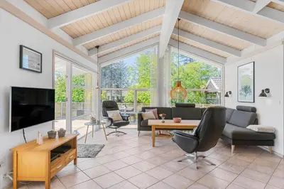 a living room with a tv and a couch and a table at BL1761-Blokhus-Hojmarksvej-44 in Blokhus