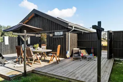a deck with a table and chairs and an umbrella at BL200-Saltum-Laustvej-9 in Saltum