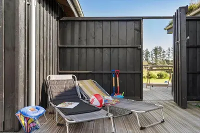 a chair sitting on a deck next to a fence at BL200-Saltum-Laustvej-9 in Saltum