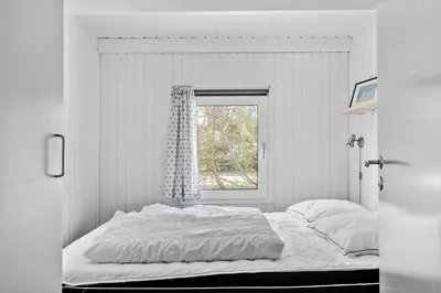 a white bedroom with a bed and a window at BL1486-Saltum-Ornebjergvej-4 in Saltum