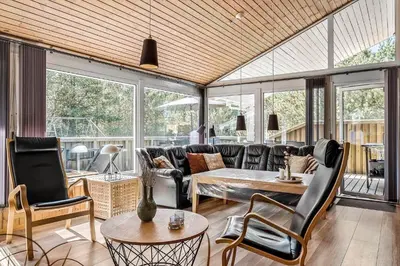 a living room with a couch and a table and chairs at BL1486-Saltum-Ornebjergvej-4 in Saltum