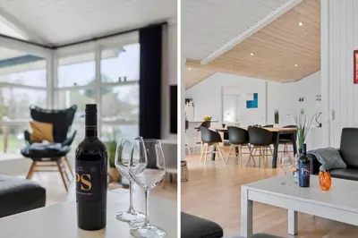 a bottle of wine sitting on a table with a wine glass at BL1713-Blokhus-Ingersvej-8 in Blokhus