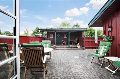 a patio with chairs and a table and a building at BL1743-Pandrup-Rodhus-Skolevej-14 in Pandrup