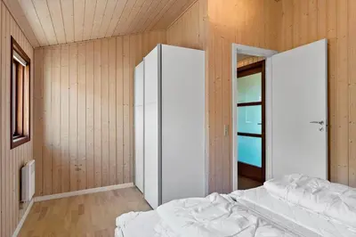 a bedroom with a white bed and a closet at BL1311-Saltum-Kordalsvej-90 in Saltum