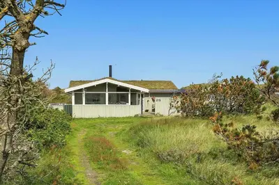 a white house with a dirt road in front of it at BL1448-Pandrup-Hunetorp-Klitvej-215 in Pandrup