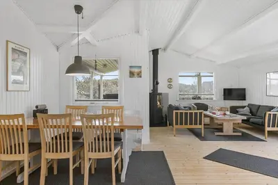 a dining room and living room with a table and chairs at BL1448-Pandrup-Hunetorp-Klitvej-215 in Pandrup