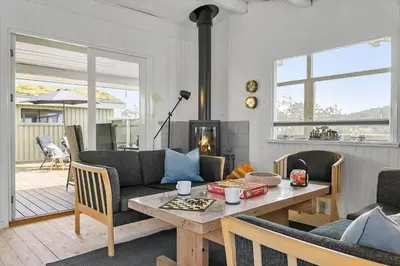 a living room with a table and a fireplace at BL1448-Pandrup-Hunetorp-Klitvej-215 in Pandrup