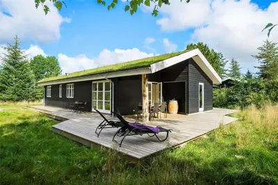 a tiny house with a grass roof on a deck at BL1704-Blokhus-Pirupvejen-66 in Blokhus