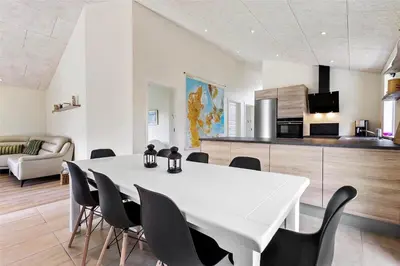 a dining room with a white table and chairs at BL1704-Blokhus-Pirupvejen-66 in Blokhus