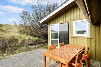 a wooden table and chairs outside of a house at BL612-Pandrup-Sydvej-10 in Pandrup