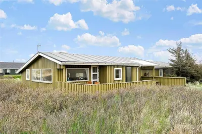 a yellow house with a metal roof on a field at BL612-Pandrup-Sydvej-10 in Pandrup