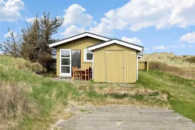 a small yellow house sitting on top of a hill at BL612-Pandrup-Sydvej-10 in Pandrup