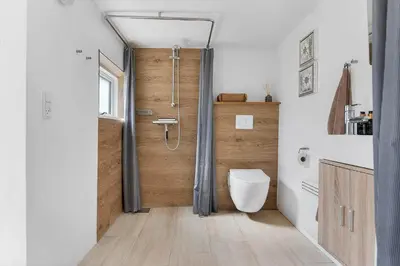 a bathroom with a shower and a toilet in it at BL1550-Blokhus-Poppelvej-10 in Blokhus