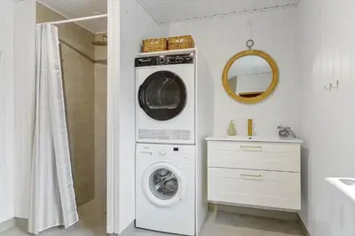 a washer and dryer in a bathroom with a sink at BL1567-Blokhus-Klitvejen-6 in Blokhus