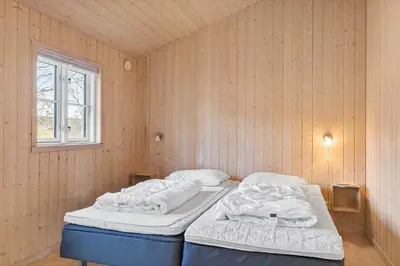 a bedroom with two beds in a room with a window at BL1639-Blokhus-Bloksbjerg-57 in Blokhus