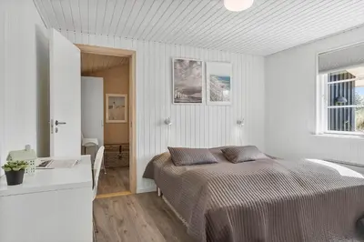 a bedroom with a bed in a white room at BL1639-Blokhus-Bloksbjerg-57 in Blokhus