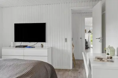 a bedroom with a television on a white wall at BL1639-Blokhus-Bloksbjerg-57 in Blokhus