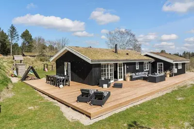 a house with a wooden deck in front of it at BL1639-Blokhus-Bloksbjerg-57 in Blokhus