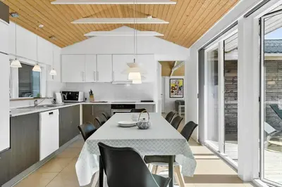a kitchen and dining room with a table and chairs at BL1236-Pandrup-Kirkekrogen-5 in Pandrup