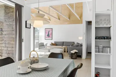 a dining room and living room with a table and chairs at BL1236-Pandrup-Kirkekrogen-5 in Pandrup
