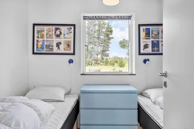 a bedroom with two beds and a window at BL1236-Pandrup-Kirkekrogen-5 in Pandrup