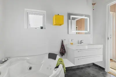 a white bathroom with a tub and a sink at BL448-Saltum-Nordvestvej-1 in Saltum