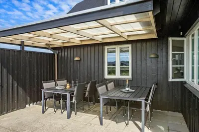a patio with a table and chairs under a pergola at BL854-Saltum-Porsevej-6-A in Saltum