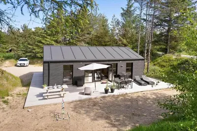 a tiny house with a picnic table and a grill at BL1565-Blokhus-Plantagevej-2-A in Blokhus