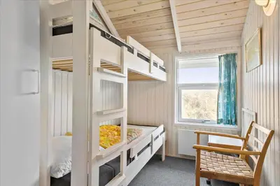 a bedroom with two bunk beds and a window at BL1747-Blokhus-Norresundbyvej-22 in Blokhus