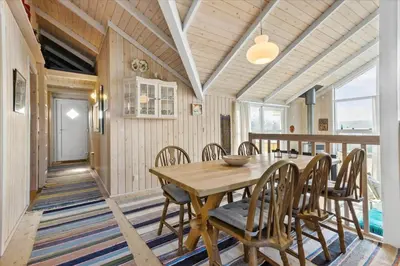 a dining room with a wooden table and chairs at BL1747-Blokhus-Norresundbyvej-22 in Blokhus
