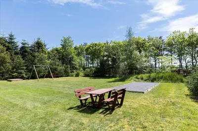 a picnic table and a swing set in a field at BL410-Saltum-Store-Fiskerbanke-4 in Saltum