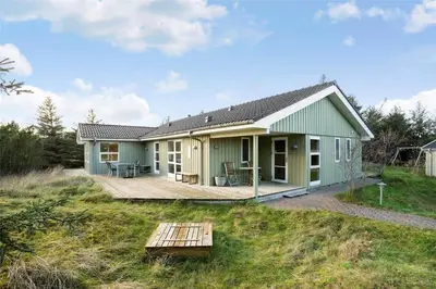 a green house with a deck in front of it at BL1233-Saltum-Krogsletten-14 in Saltum