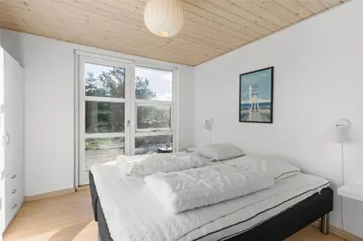 a bedroom with a bed with white walls and windows at BL1233-Saltum-Krogsletten-14 in Saltum
