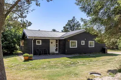a small black house with a yard at BL1417-Blokhus-Frederiksensvej-16 in Blokhus