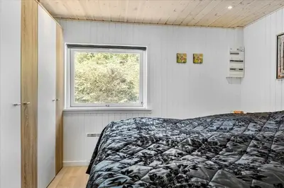 a bedroom with a bed and a window at BL1417-Blokhus-Frederiksensvej-16 in Blokhus