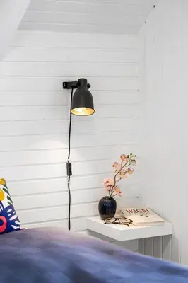 a lamp in a bedroom with a vase on a table at BL1549-Blokhus-Bakkevaenget-11 in Blokhus