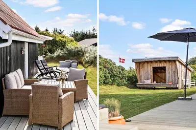 a patio with a table and an umbrella and a house at BL1549-Blokhus-Bakkevaenget-11 in Blokhus