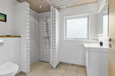 a bathroom with a toilet and a sink and a window at BL1522-Saltum-Kordalslien-25 in Saltum